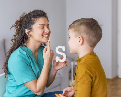 Une femme montrant comment faire le son S avec sa bouche a un enfant